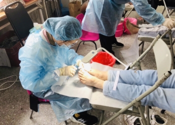 ▲中華健康促進及照護協會為年長者與不便彎腰的民眾修剪腳趾甲。（圖/嘉義縣政府提供）