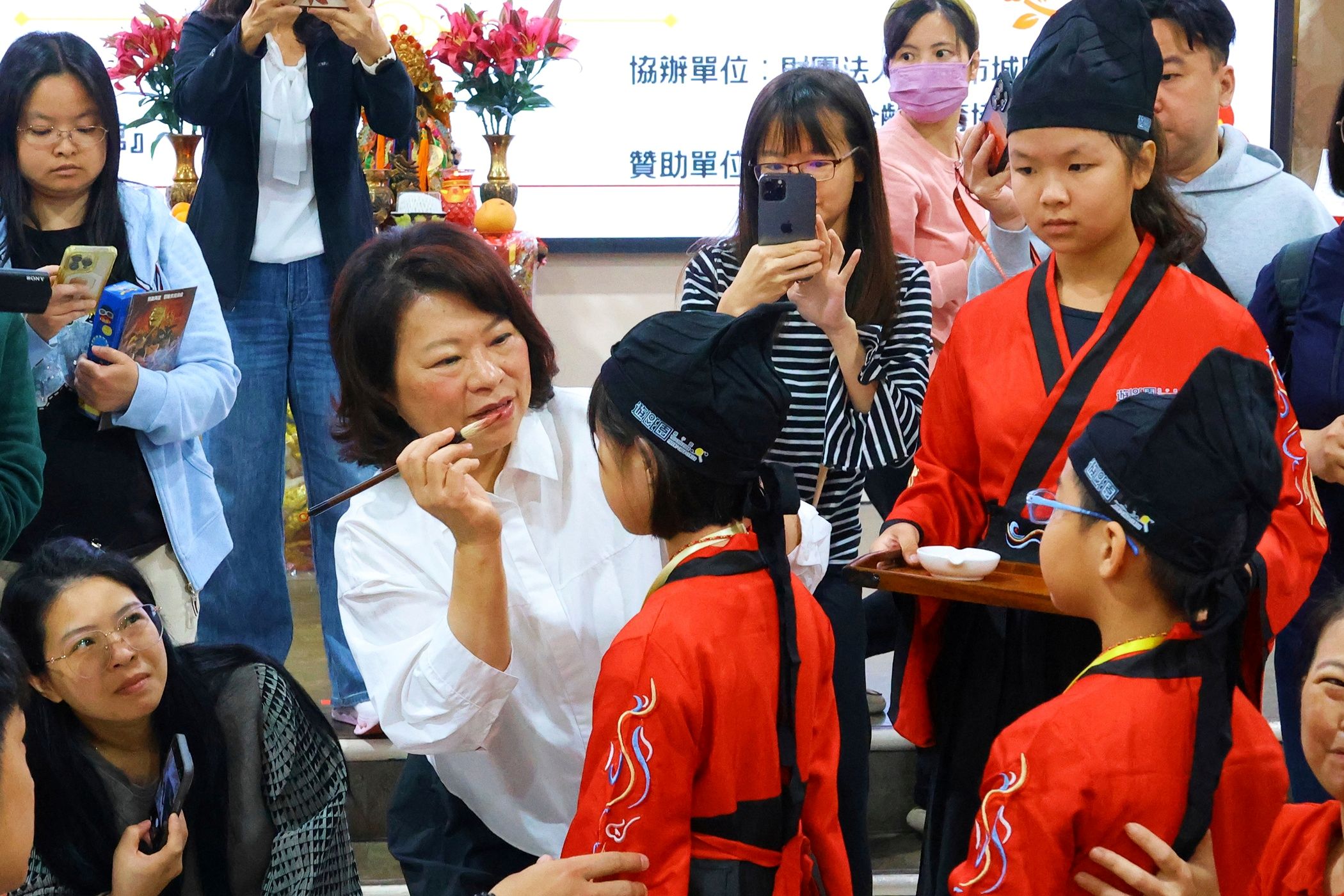 ▲嘉義市長黃敏惠親自擔任儀式啟蒙老師,為孩子們點硃砂。(圖/嘉義市政府提供)