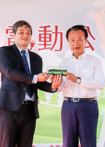 ▲華德動能科技股份有限公司總經理楊誌榮（左）致贈全新的電動公車模型給縣長翁章梁。（圖/嘉義縣政府提供）