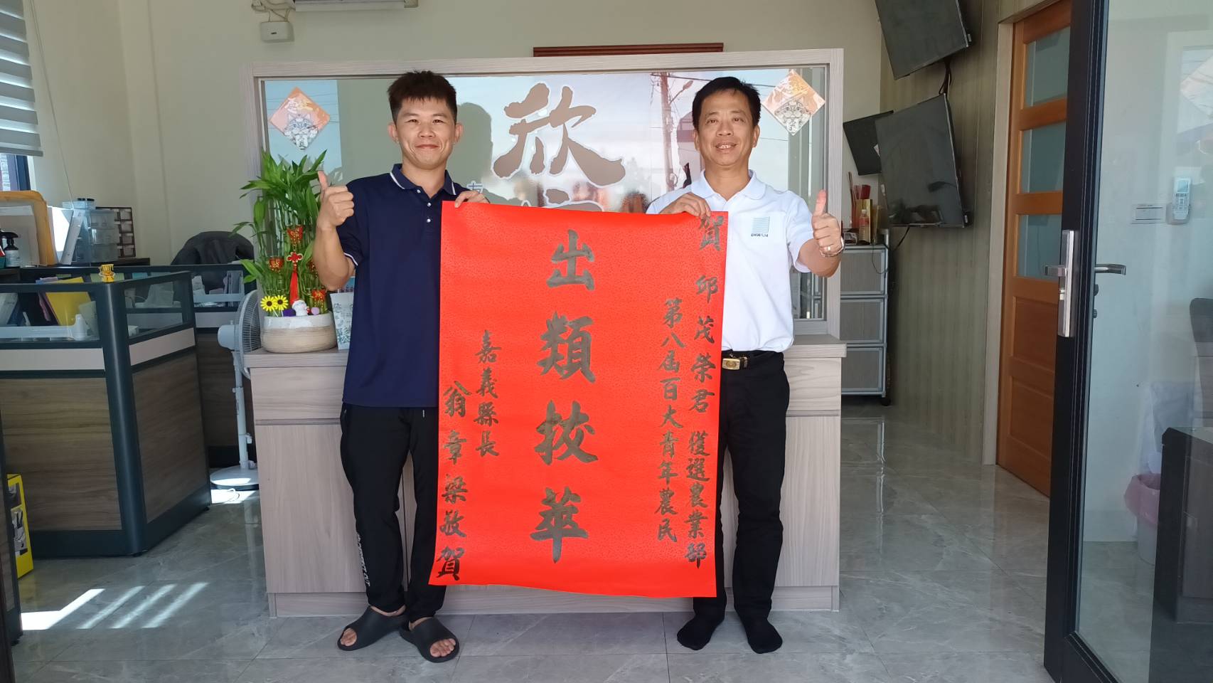 ▲邱茂榮(左)勇奪第八屆百大青農,農業處前往張貼縣長翁章梁祝賀紅榜。(圖/嘉義縣政府提供)